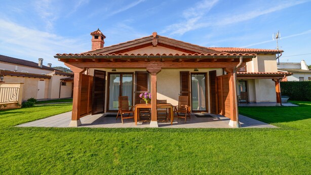 Una casa con patio, comedor y zona de estar techada al aire libre.