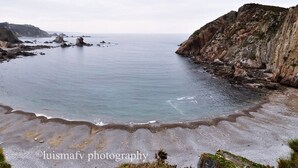Un paisaje costero con acantilados rocosos y una playa de arena.