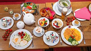 Un bufé de desayuno con diversos platos, como huevos, aguacate y fruta.