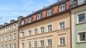 A row of European-style buildings with a café in the center. - Hotel Deutsche Eiche (Munich)