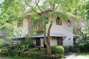 A two-story house with a balcony, surrounded by lush greenery and a well-maintained garden. - Lilawalai Resort (Pak Chong)