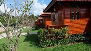 Una casa de madera con balcón y jardín.