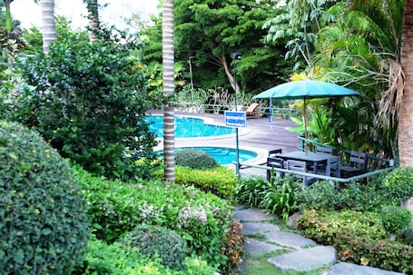 Una piscina al aire libre, sillones reclinables de piscina