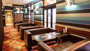 Un restaurante con paredes a rayas, cabinas y mesas.