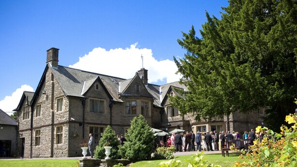 A stone building with a traditional architectural style, featuring multiple windows and a well-maintained lawn. - Maes Manor Hotel (Blackwood)