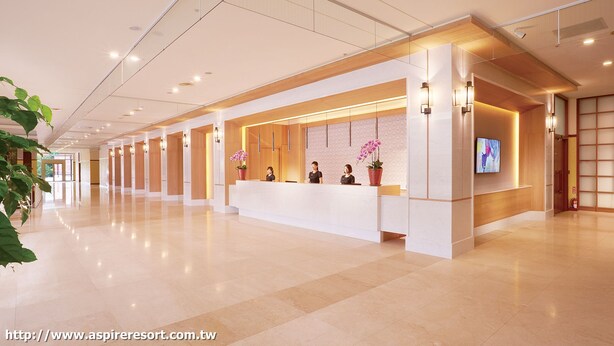 A modern hotel reception area with a long reception desk, glass panels, and a flat-screen TV. - Aspire Resort (Taoyuan City)