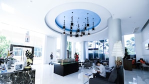 A spacious lobby with a modern chandelier, seating areas, and a reception desk. - Atlantis Condo Resort by Natnarin (Pattaya)