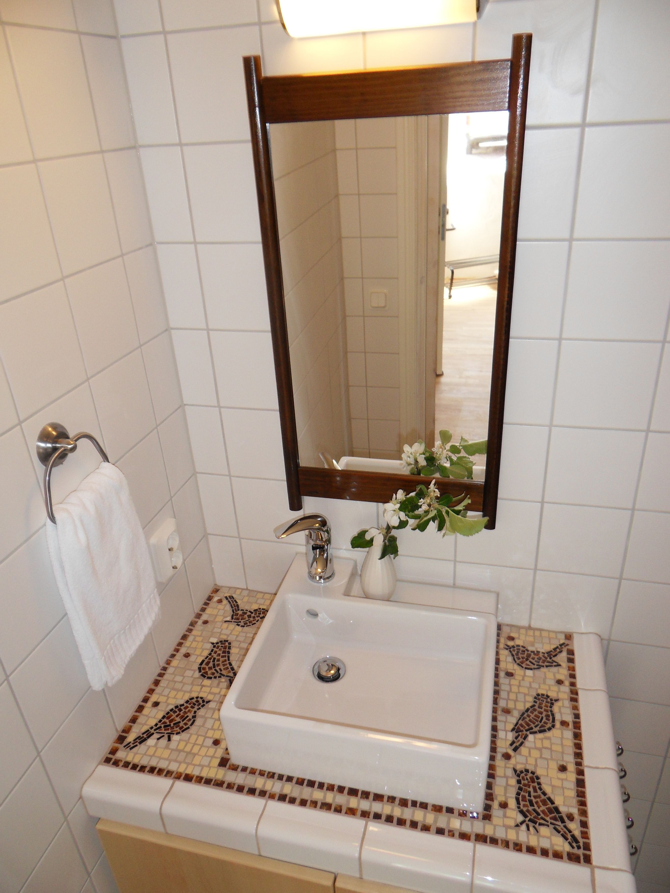 Ein Badezimmer mit Waschbecken, Spiegel und Handtuchhalter.