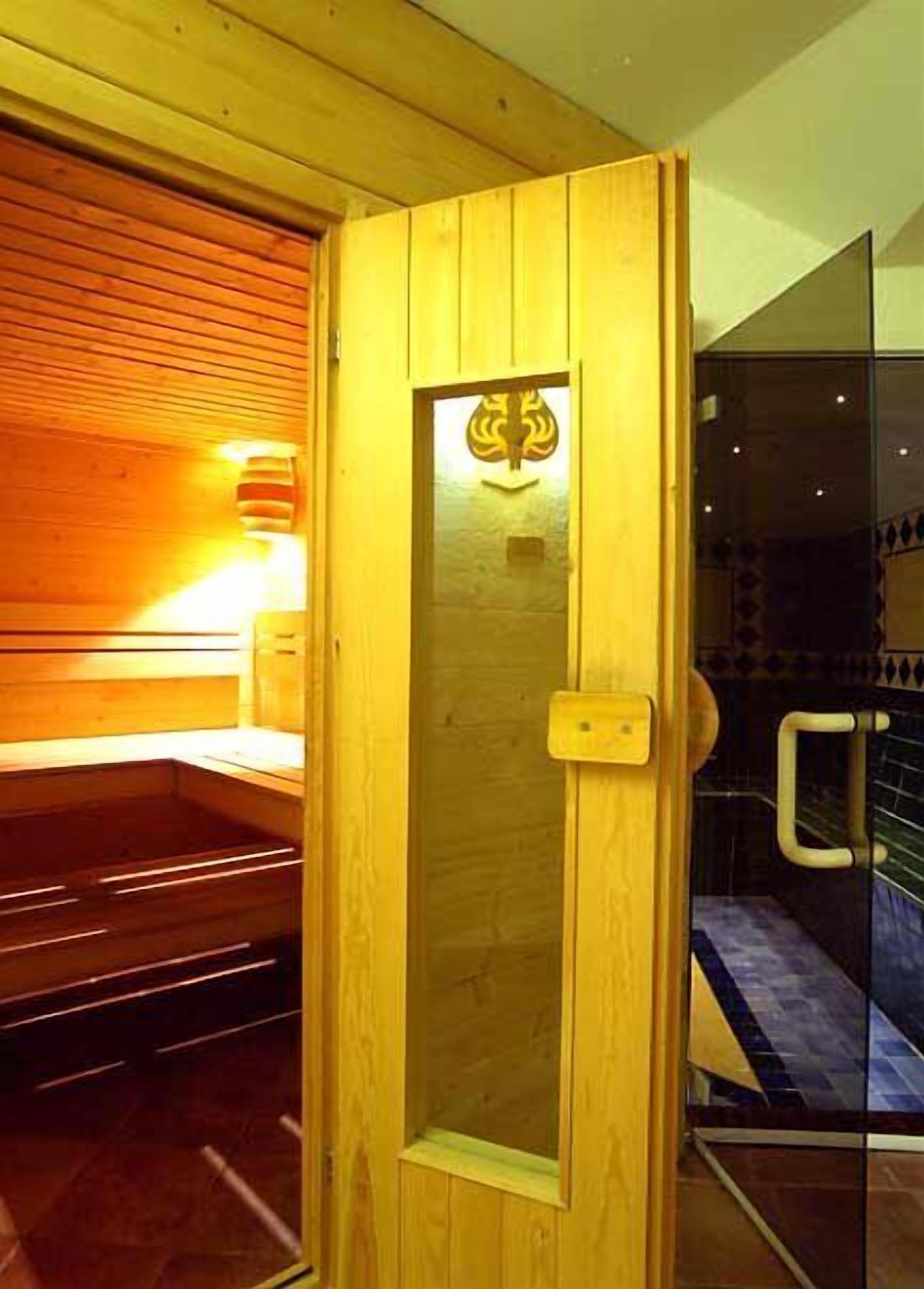 Una sauna con pareti in legno e una porta in vetro.
