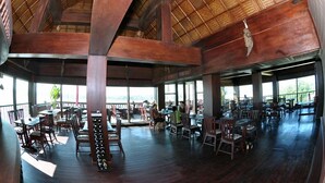 Un restaurante amplio con techos altos y ventanas grandes.