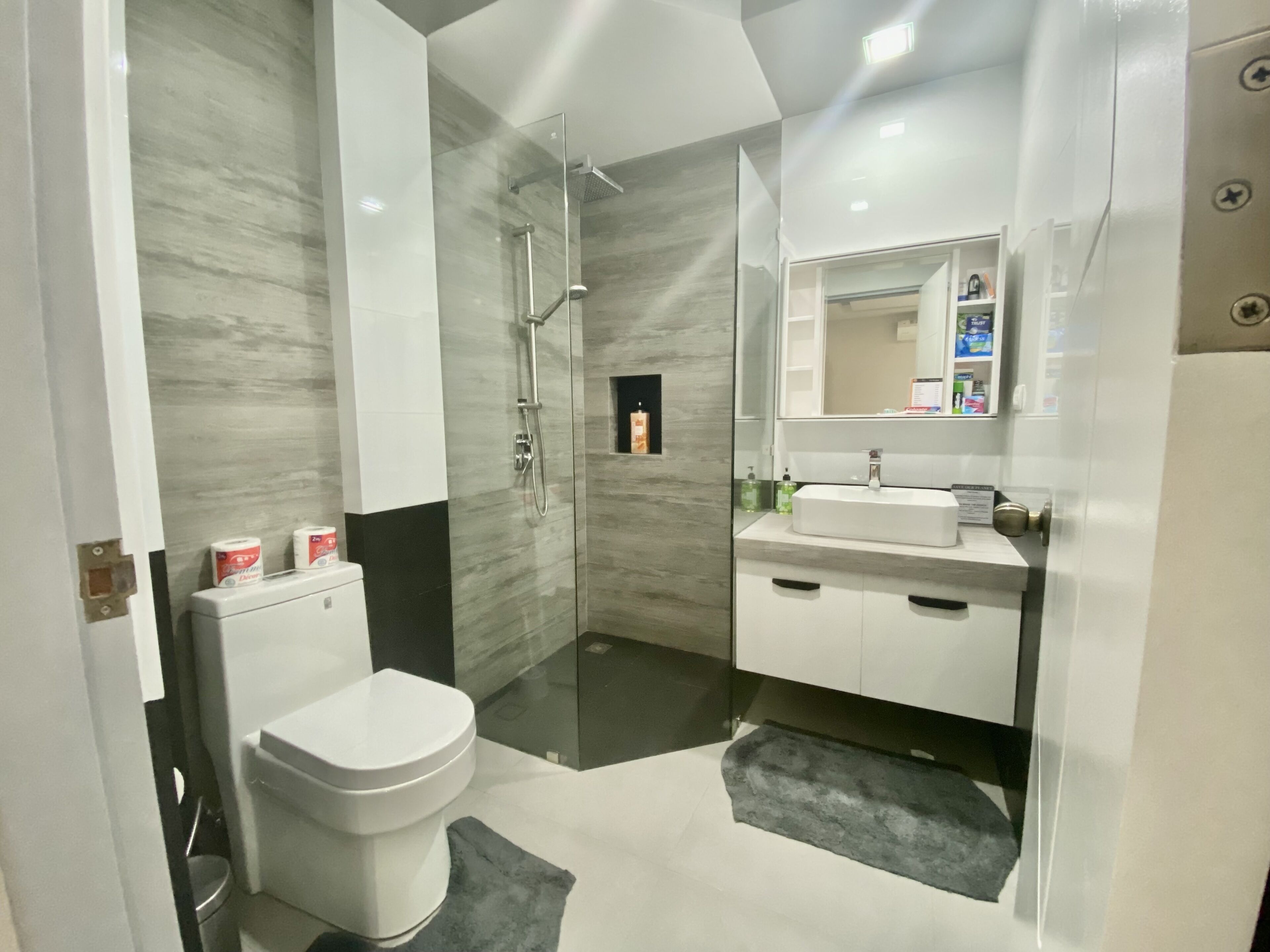 A modern bathroom with a toilet, sink, and shower.