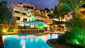 A swimming pool with a lounge area, a restaurant, and a building with balconies. - Lalaguna Villas Luxury Dive Resort & Spa (Puerto Galera)