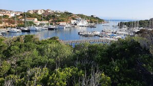 A marina with boats docked, surrounded by greenery and buildings in the background. - Appartamenti Santa Teresa Gallura (Santa Teresa di Gallura)