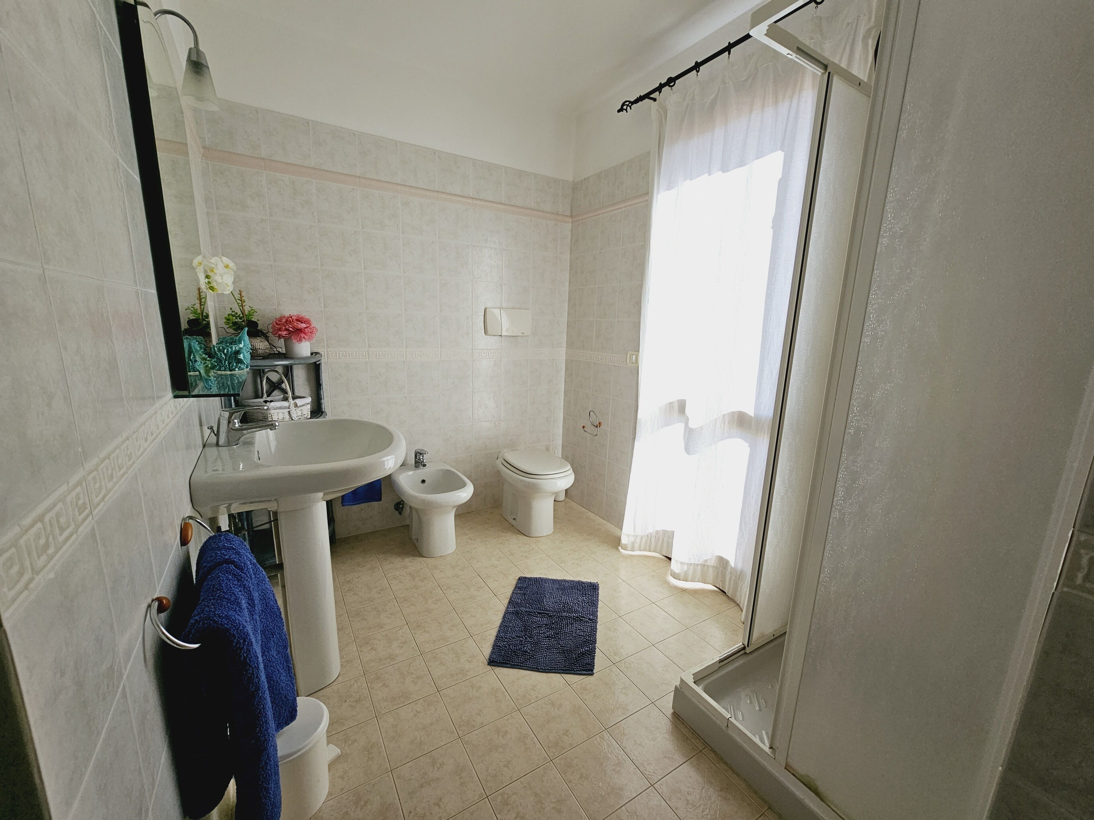 Une salle de bain comprenant un lavabo, un bidet, des toilettes et un espace douche.