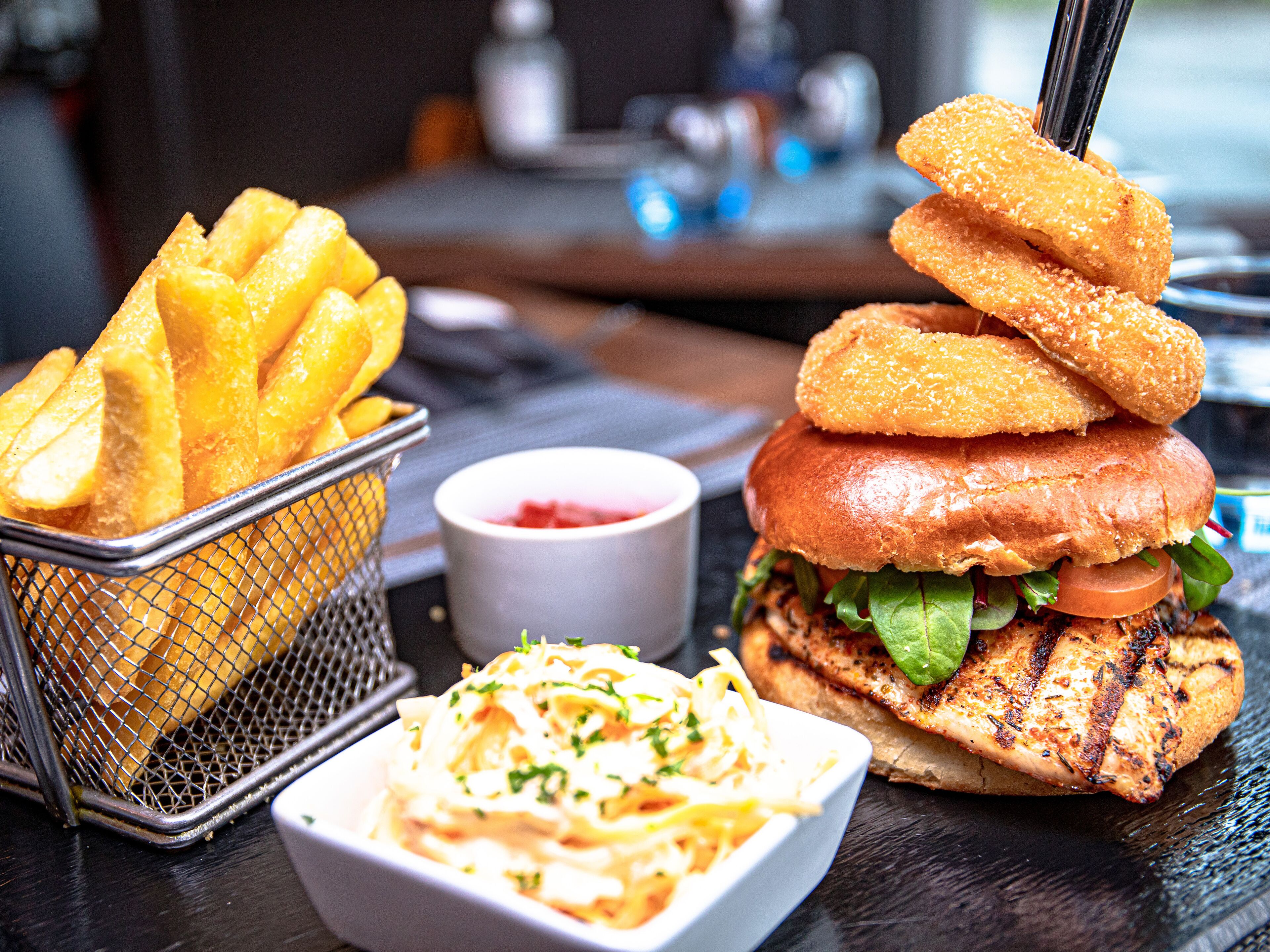 Een maaltijd bestaande uit een hamburger, friet en uienringen.