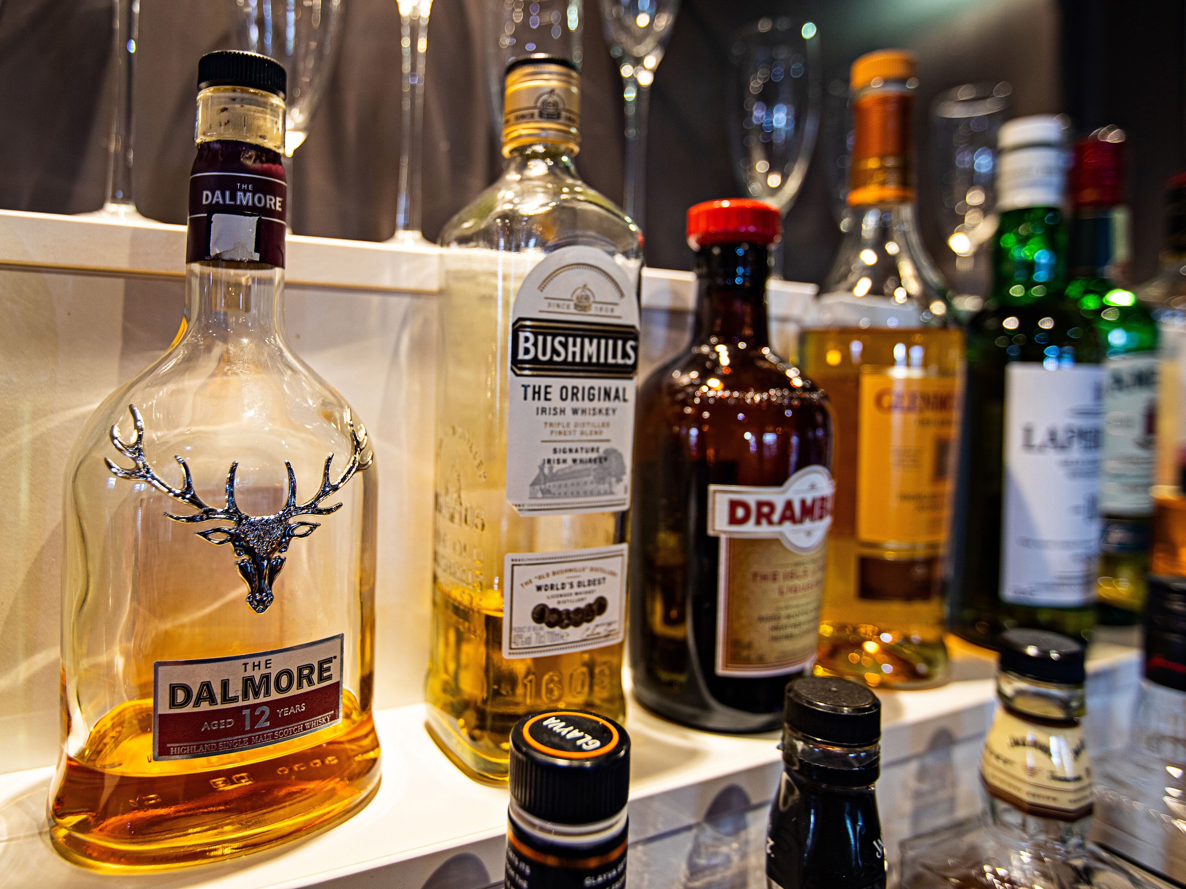 A variety of liquor bottles on a shelf.