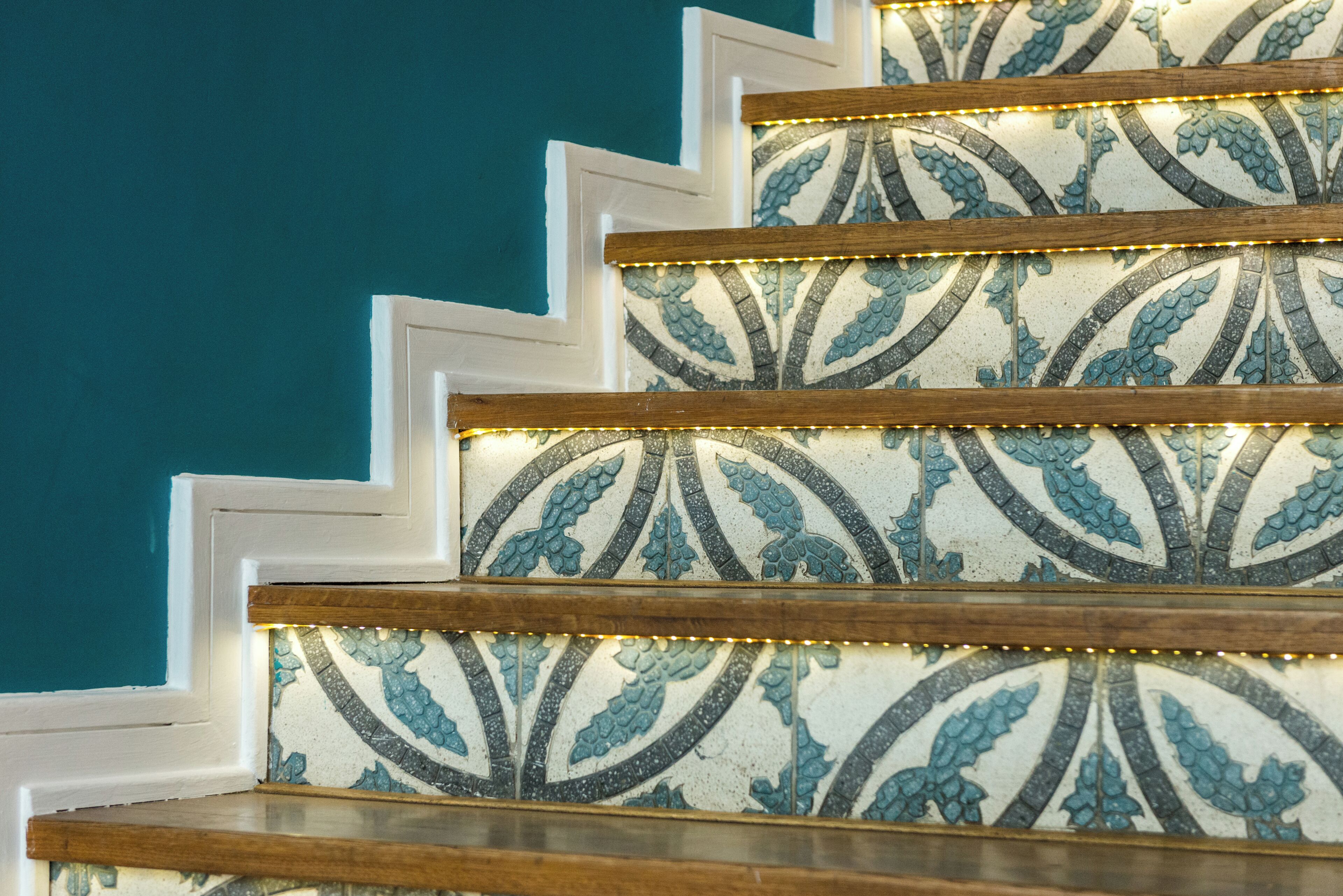 A staircase with a patterned tile design and wooden handrails.