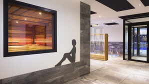 A modern interior with a large framed window, a stone accent wall, and a glass door leading to a pool area. - Saint Charles Hôtel & Spa (Val-Cenis)