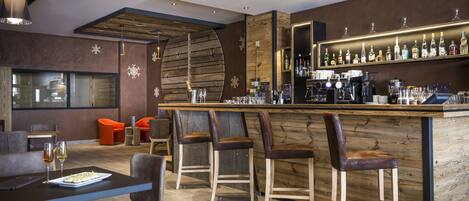 A modern bar area with wooden accents, bar stools, and a well-stocked liquor shelf.