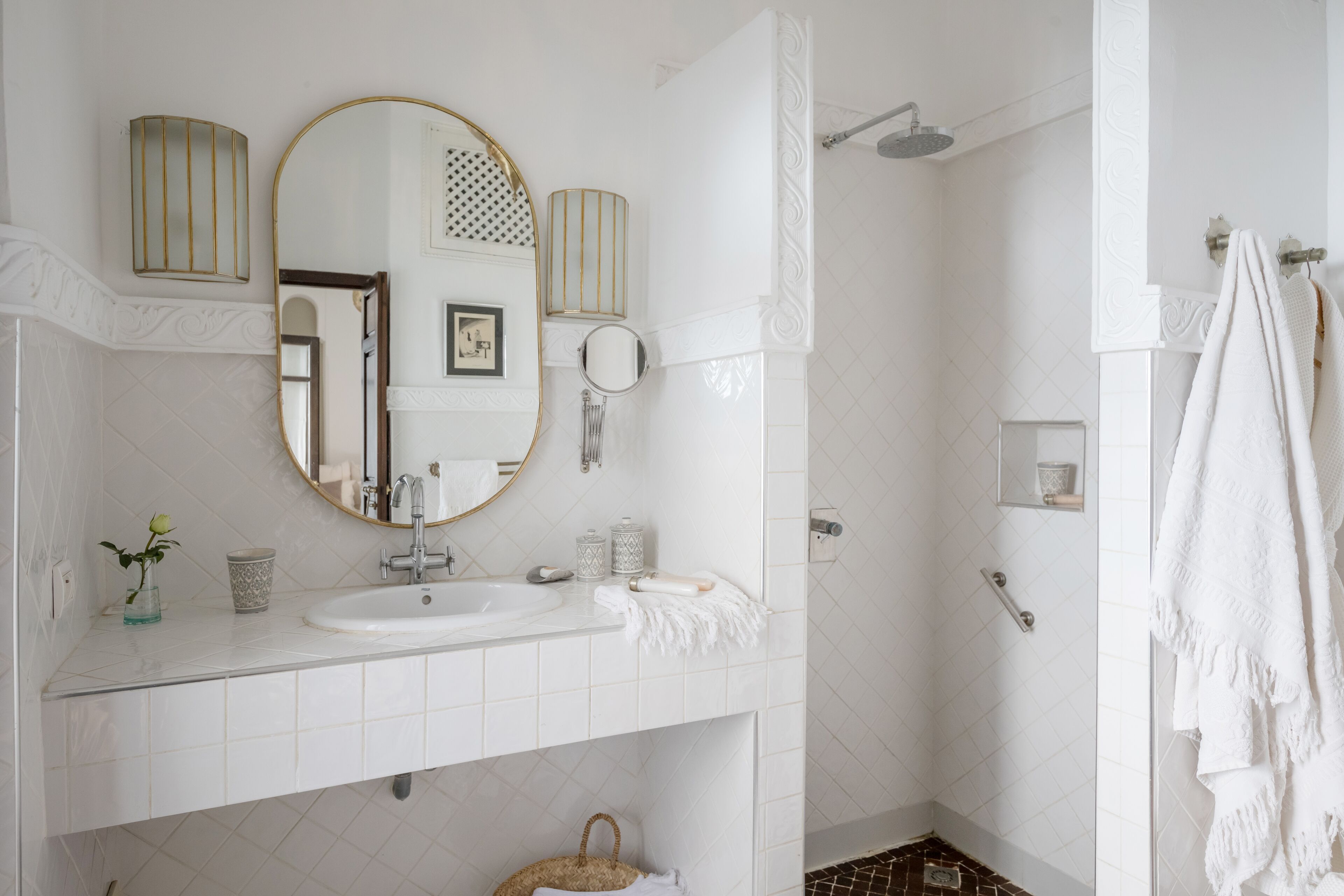 A modern bathroom with a white sink, mirror, and shower.