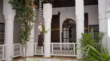 A white building with columns, a decorative star, and a wooden door.