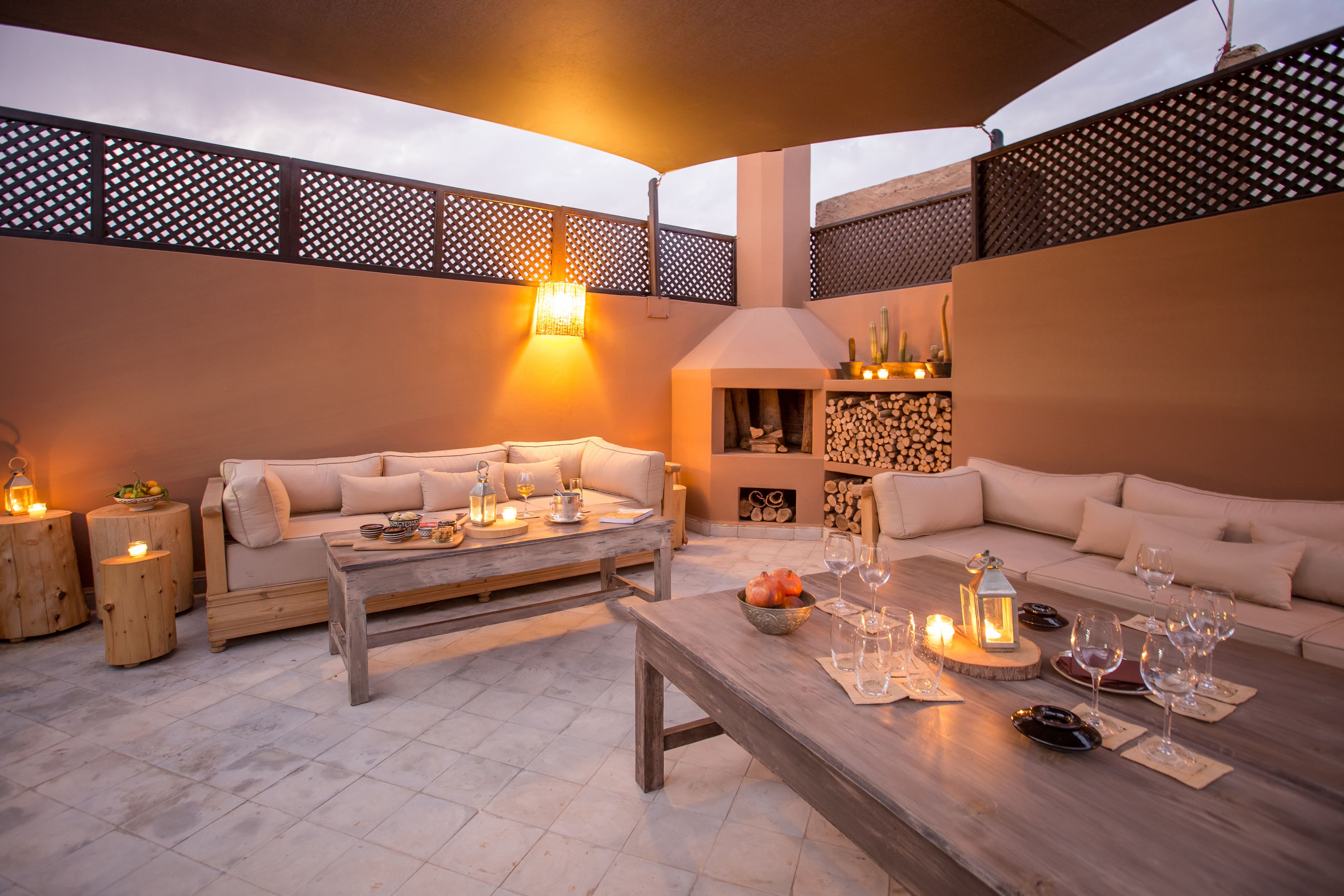 A cozy outdoor seating area with two sofas, a wooden coffee table, and a fire pit.