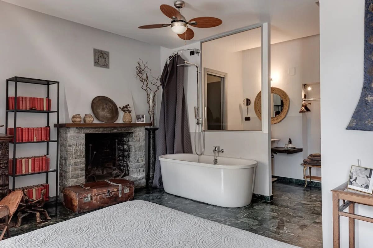 Un baño con una bañera independiente, un espejo y una ducha.