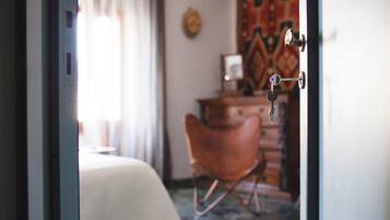 Una habitación con cama, una silla, un escritorio y una puerta con llave en la cerradura.