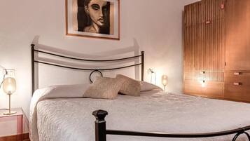 Ein Bett mit Metallgestell, eine Nachttischlampe und eine Wandleuchte.