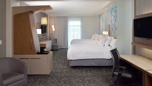 A hotel room with a bed, desk, chair, TV, and artwork on the wall. - Courtyard by Marriott Youngstown Canfield (Canfield)