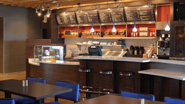 A modern restaurant with a bar area, seating, and a menu display. - Courtyard by Marriott Youngstown Canfield (Canfield)