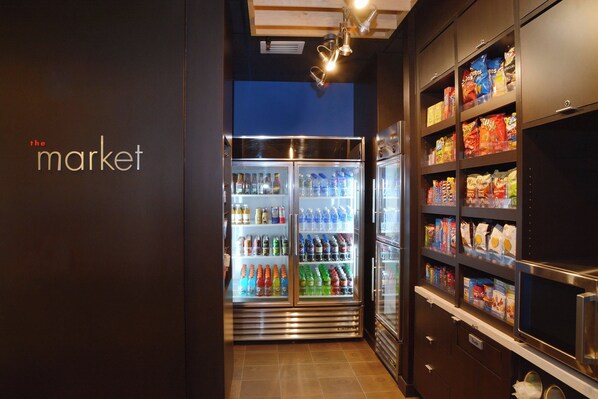 Un espace de vente proposant un distributeur automatique et un réfrigérateur rempli de boissons et d’en-cas.