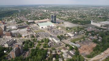 An aerial view of a cityscape with various buildings, roads, and green spaces.