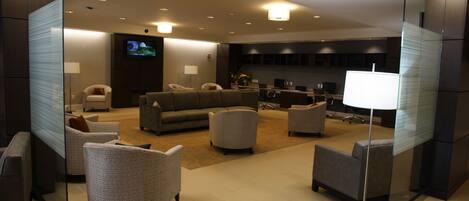 Una sala de estar moderna con un sofá, sillones y una televisión.