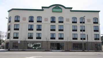 A multi-story hotel with a green roof and a sign reading "Wingate by Wyndham".