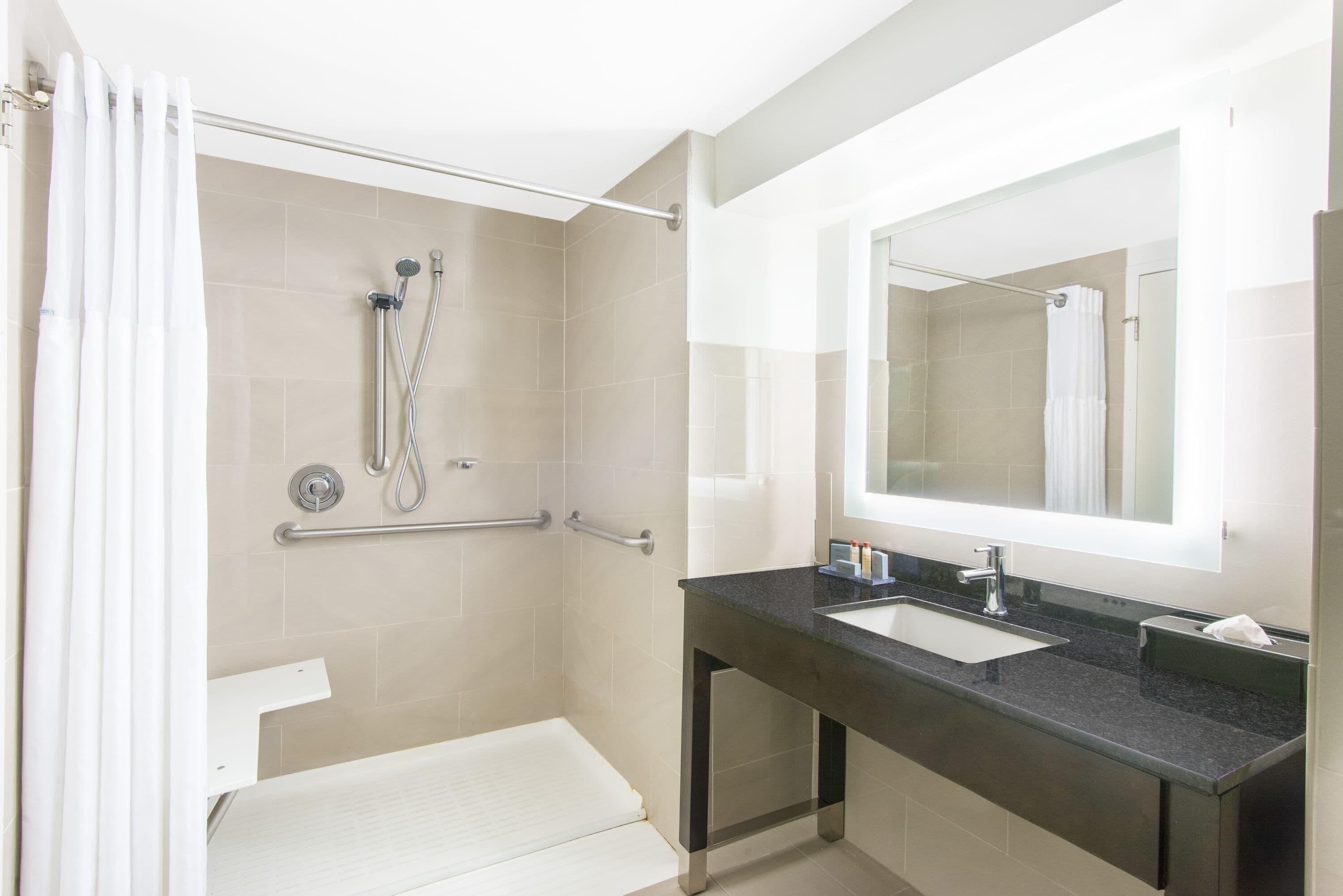 A modern bathroom with a shower, a sink, and a mirror.