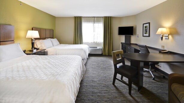 A hotel room with two beds, a desk, a chair, a TV, and a window with curtains. - Candlewood Suites Smyrna - Nashville by IHG (Smyrna)