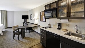 A compact hotel room with a kitchenette, a dining area, a bed, and a TV. - Candlewood Suites Smyrna - Nashville by IHG (Smyrna)