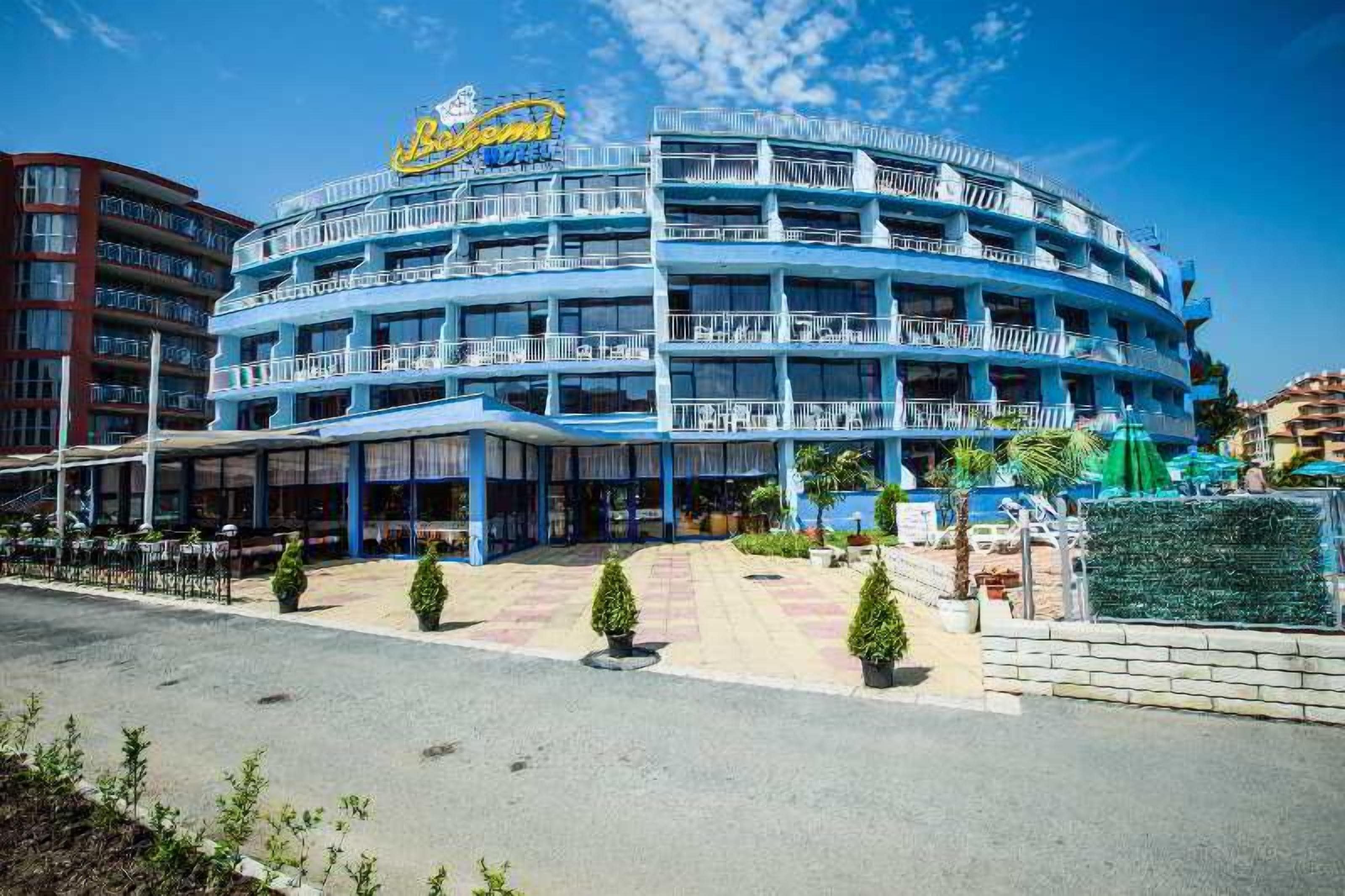 Un hotel de varios pisos con fachada azul y balcones, que muestra un letrero llamativo que dice 'Bimini'.