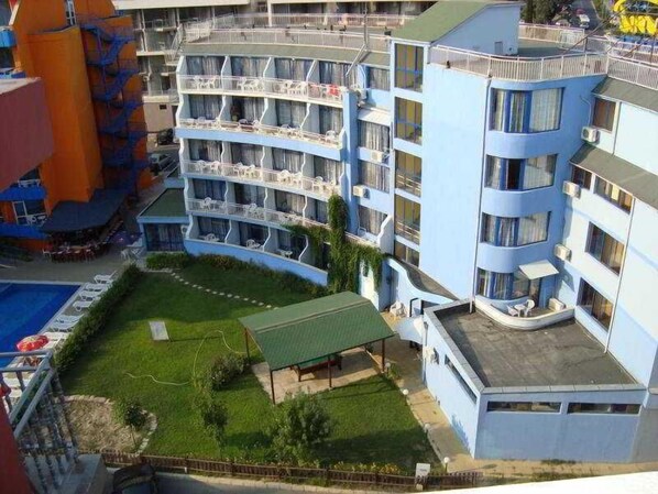 A multi-story hotel with balconies, a swimming pool, and a covered outdoor area. - Bohemi (Nessebar)