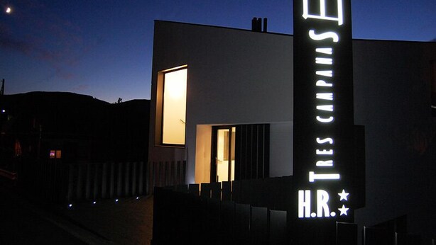 Een modern gebouw met een opvallend verlicht bord waarop 