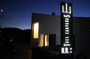 Un bâtiment moderne, doté d’une enseigne lumineuse bien visible, sur laquelle on peut lire : « Tres Carnes H.R. »