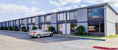 A modern building with a parking lot and a car parked in front.