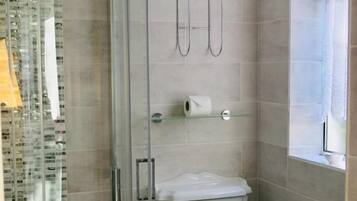 Une salle de bain avec une douche à parois de verre, des toilettes et un lavabo.