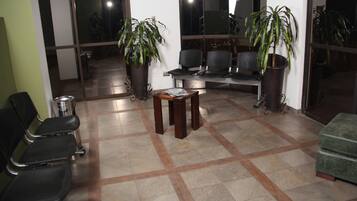 A waiting area with chairs, a table, and potted plants.