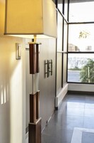 Un pasillo moderno con una lámpara de pie, una puerta con pomo y una ventana con vistas al exterior.