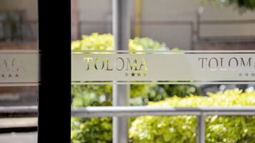 Un letrero con el nombre 'TOLOMA' y tres estrellas.