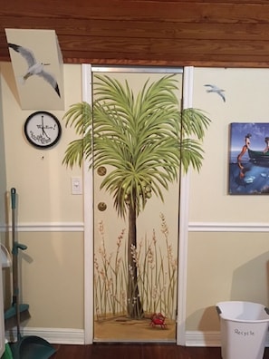 Relax in a room featuring a vibrant tropical mural, a wall clock, and a framed painting.