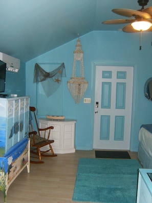 Relax in this inviting space with a comfortable rocking chair, a stylish cabinet, and a cozy rug.