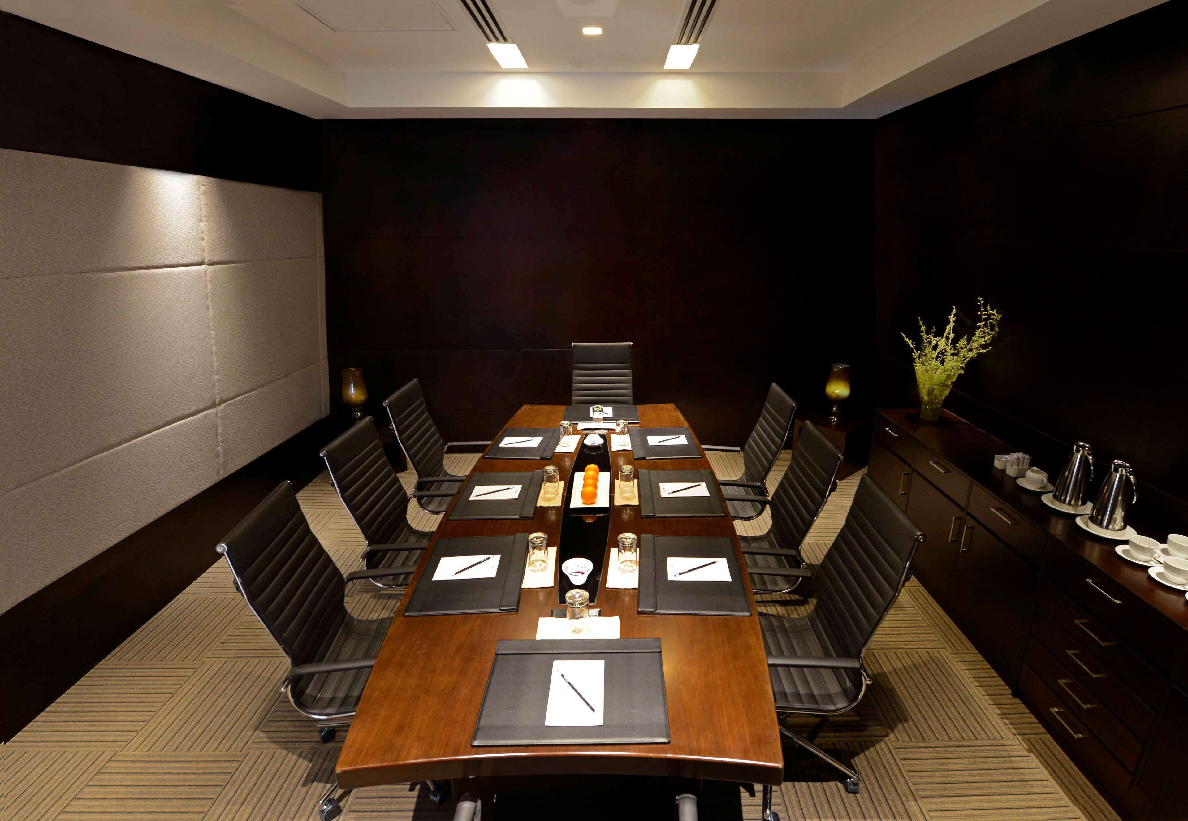 A conference room with a long table, chairs, and a coffee station.